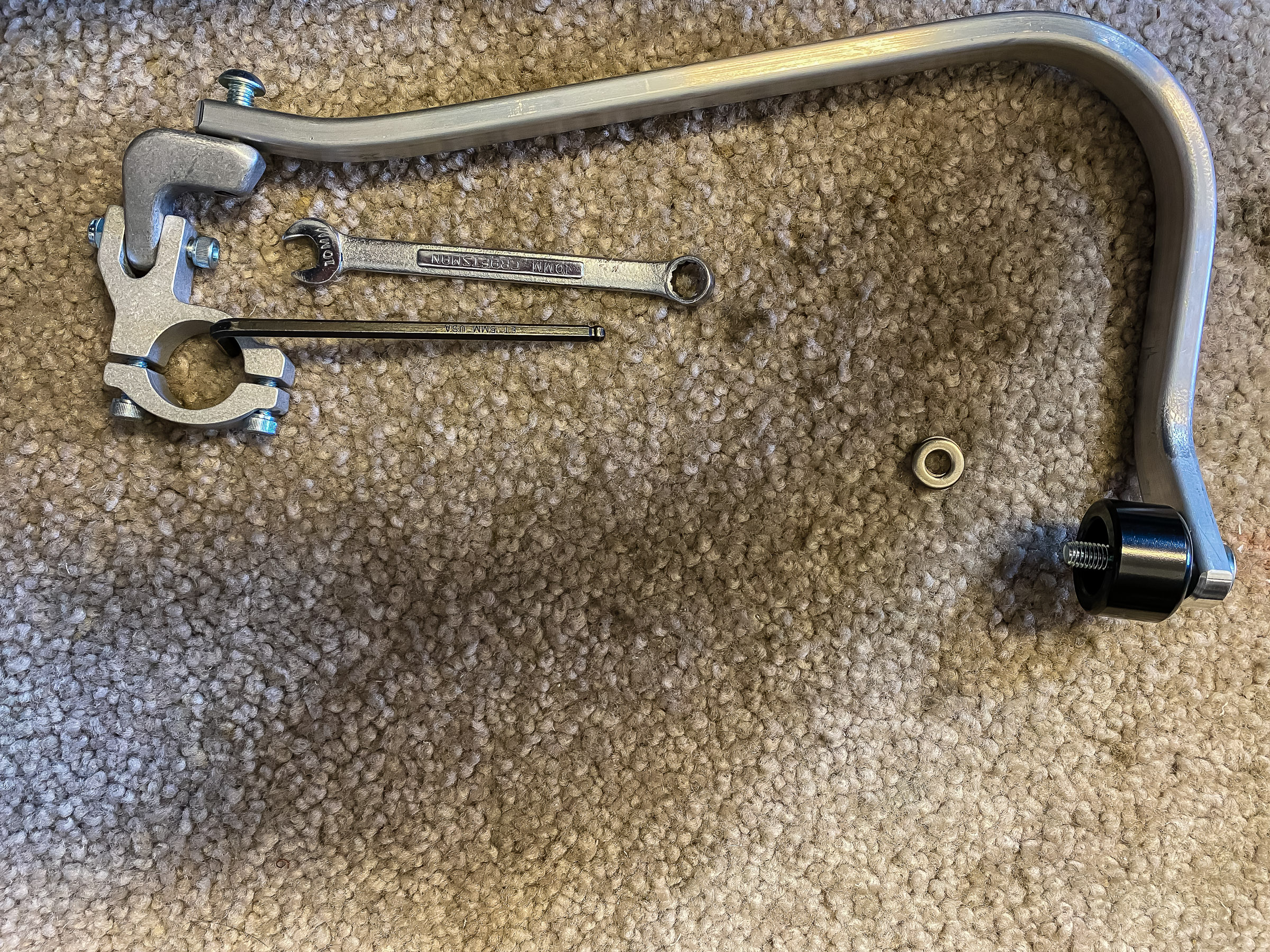 Arrange the parts on the bar. This is the right bar because the 2 small washers go between the black bar weight and the threaded insert so there's space between the throttle grip.