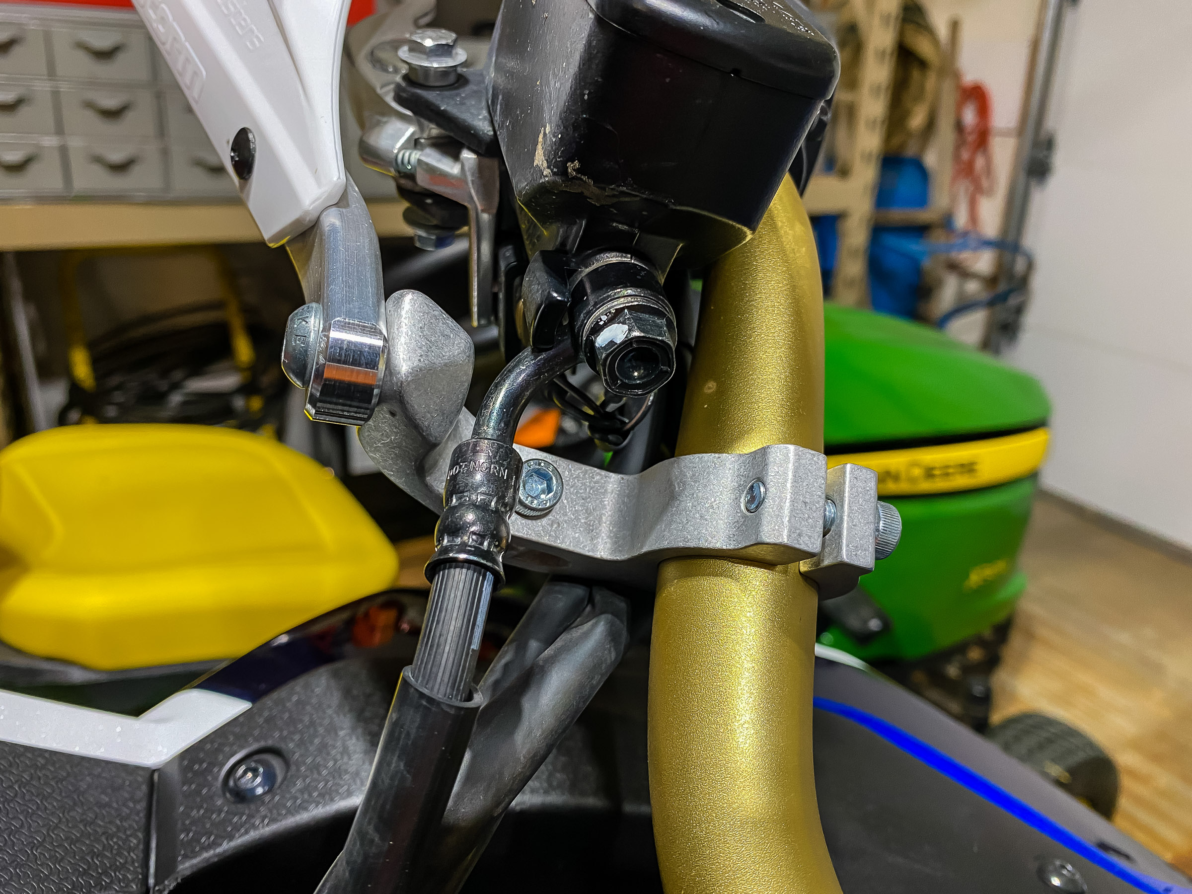 Notice how the bar clamp is under the brake line and above the wiring harness. Your bike may differ because I have ROX risers on my handlebar. Make sure the brakes line and wires are not stressed when you turn the handle bar lock to lock.