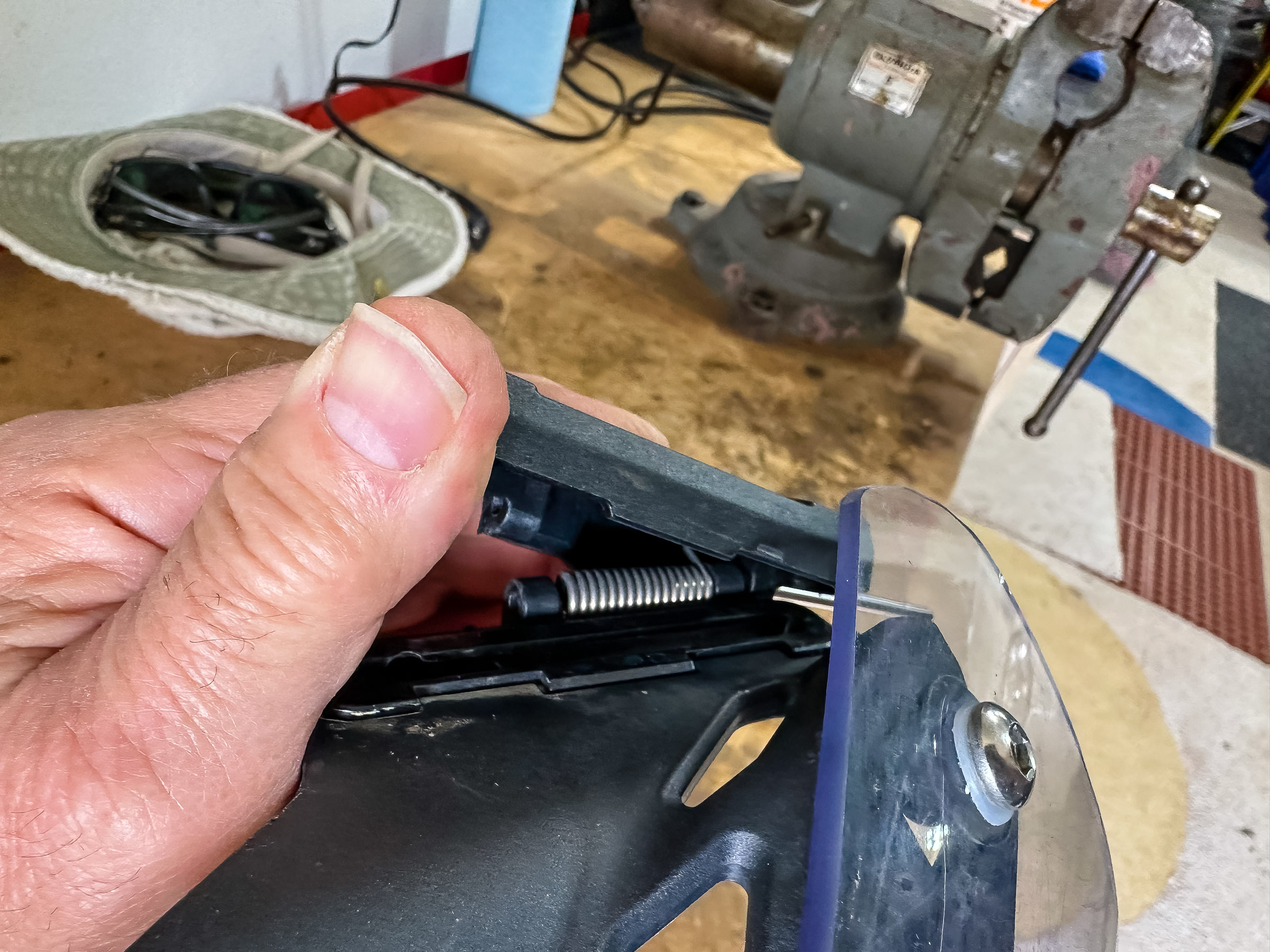 This is the lock lever spring. The hinge pin goes through the middle of it. Putting the lock lever in place with spring tension is easy. All you have to do is put the inside of the lever on top of the spring and screw in the 2 bolts.