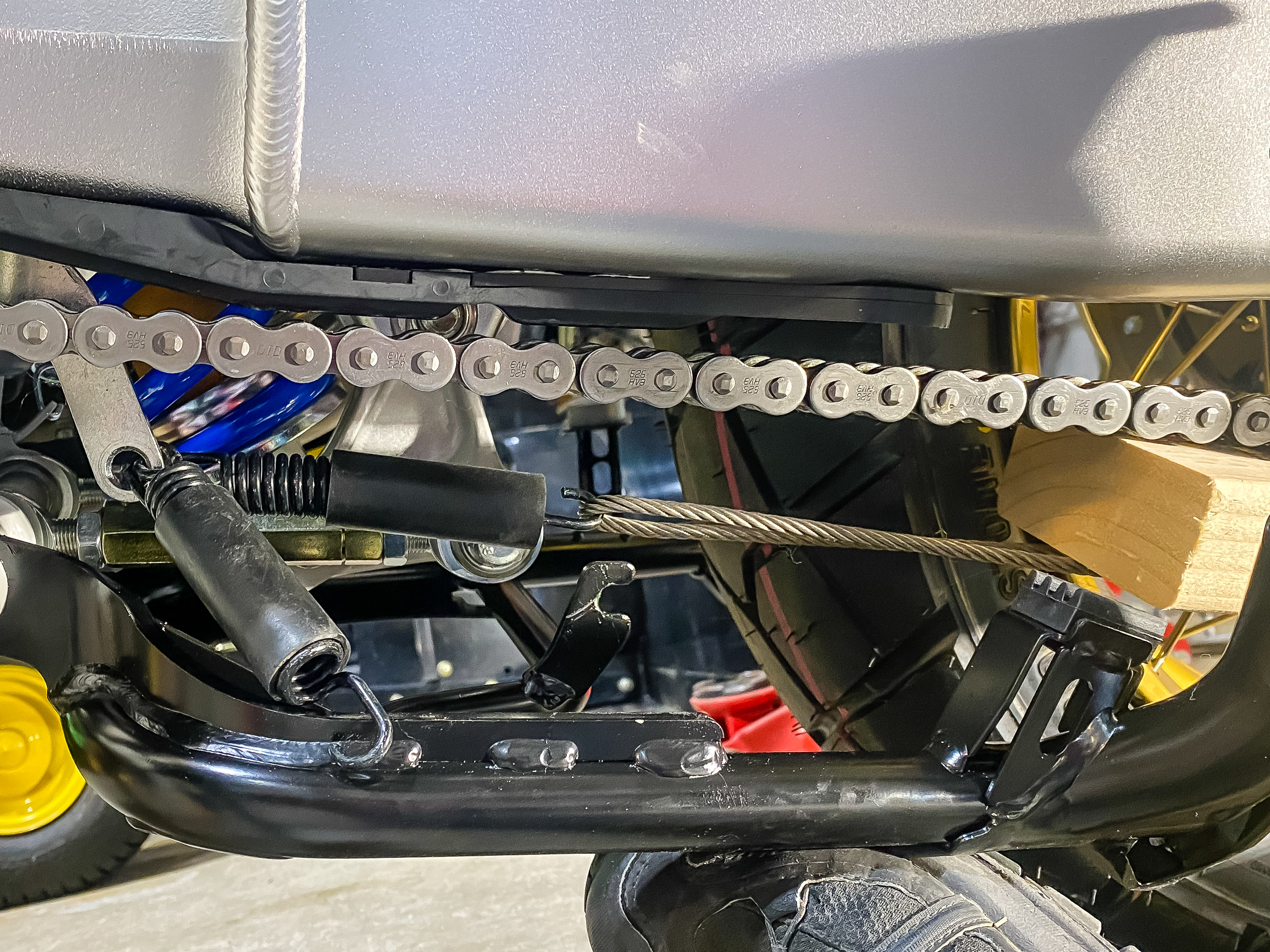 I made a 2nd loop out of some steel cable I had laying around. I aligned the bike with the cable and looped the cable on the spring hook. I stuck a piece of 2x4 to hold the cable down so it would align with the spring hook on the center stand.