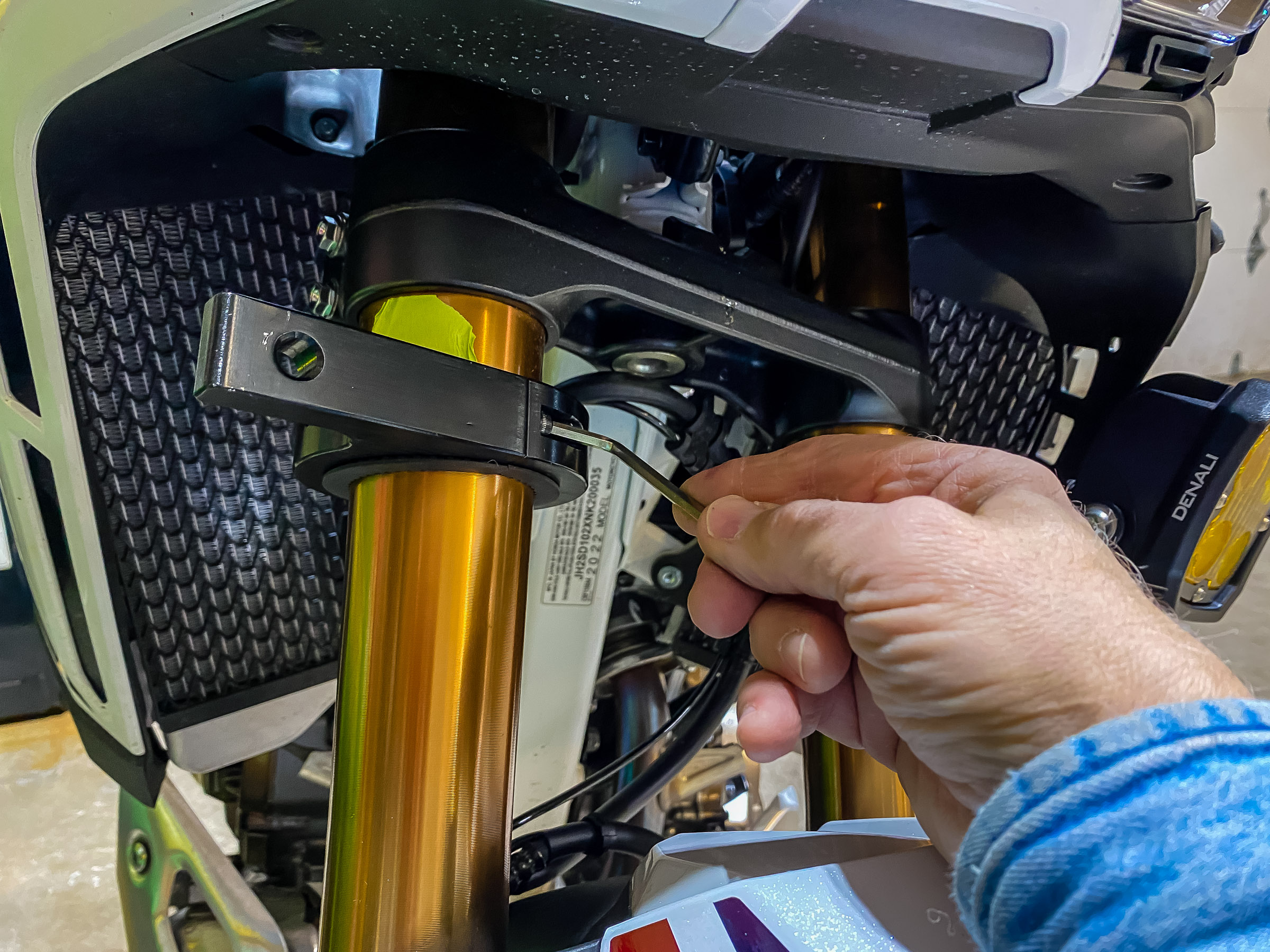 I used masking tape as a marker for the position of the mount. The fork tubes are a little smaller than the clamps so I put a strip of thin rubber between the clamp and the fork. Before I put the lights on the clamps I put a 24" level across the front surfaces to make sure they are parallel.