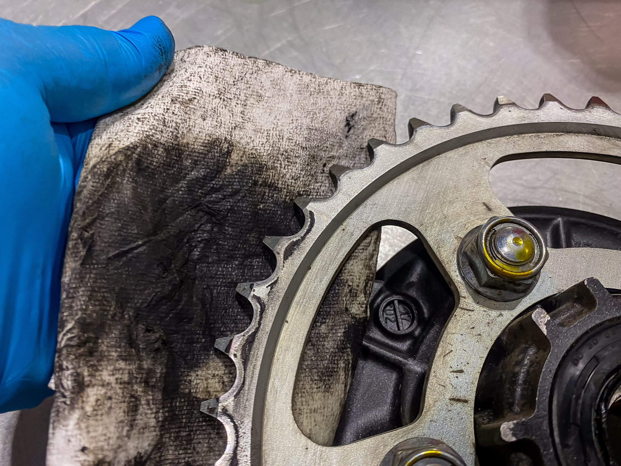 Cleaning the dirt off the sprocket with some diesel fuel on a rag. Get both sides.