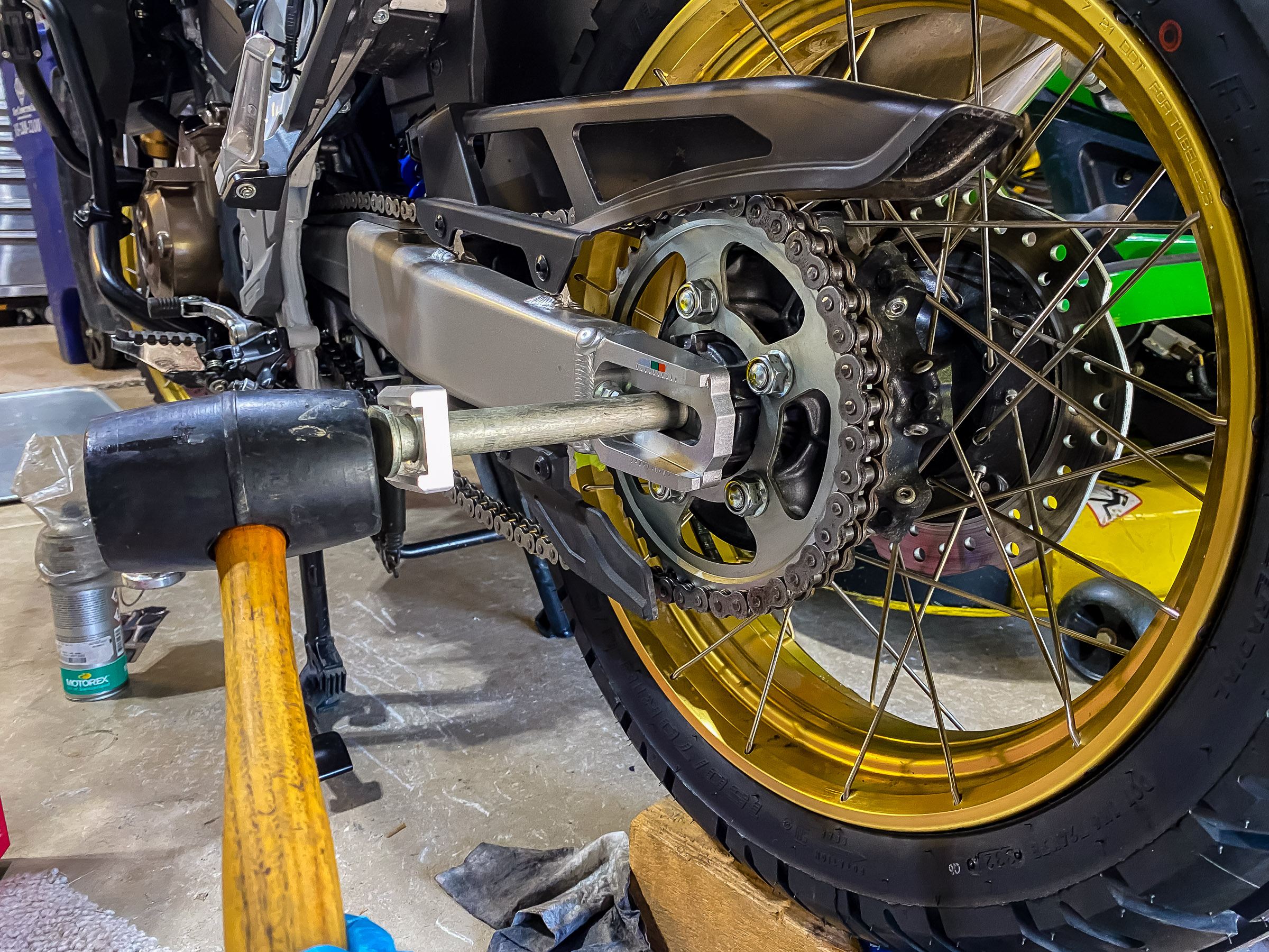 I put the chain all the way around the sprocket and tapped the axle in with a rubber hammer.