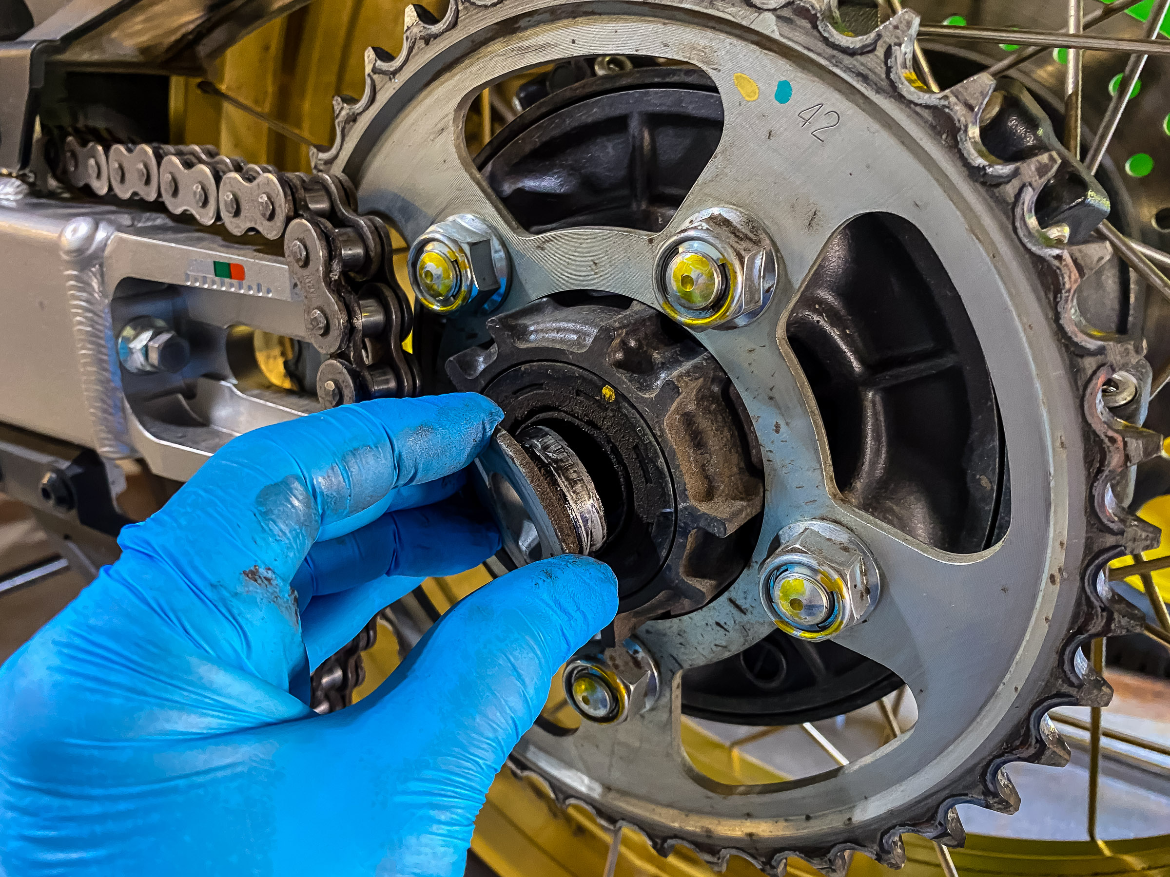 The left rear wheel flanged spacer will probably fall  out. Take it out and put it aside. You'll want to clean it up.