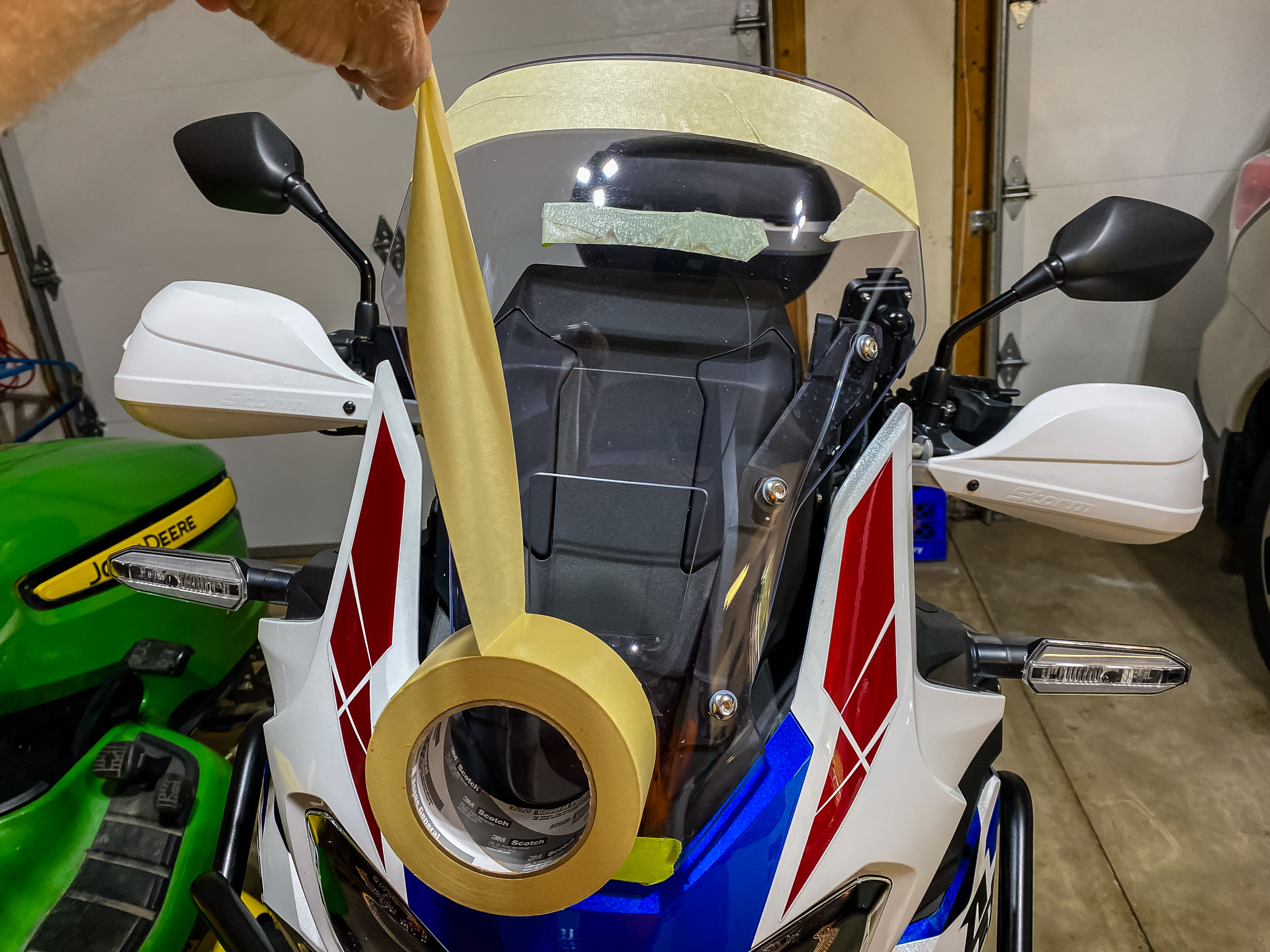 The piece of tape at the upper center is a test view locator I drove around with to establish a viewpoint. The windshield on this bike can adjust up by 2". Cover both sides of the windshield with masking tape to draw the layouot and to prevent scratches.