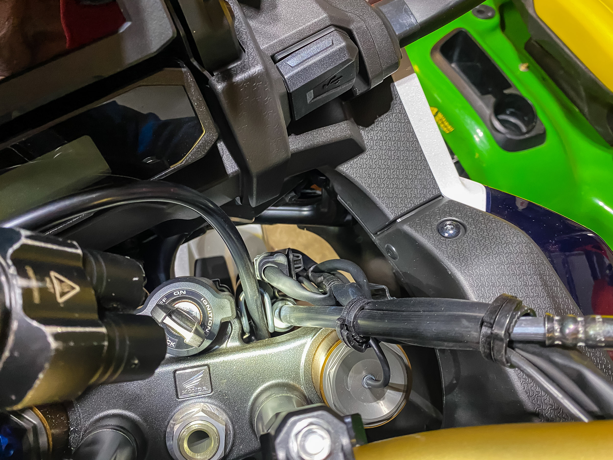 Now that you moved the handlebar you'll have to reroute some of the cables to loosen them up. Remove and reposition cable ties. The brake line has a rubber grommet that runs through a metal retainer clip. Push the grommet out of the clip to give it more slack.